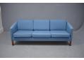 Compact 3 seat box frame sofa in blue fabric with gently curved frame ends. 