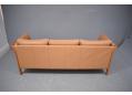 Wood frame end sofa in cherry with light caramel colour leather upholstery.