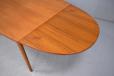 Midcentury teak dining table with shaped table top and matching pull our draw leaves